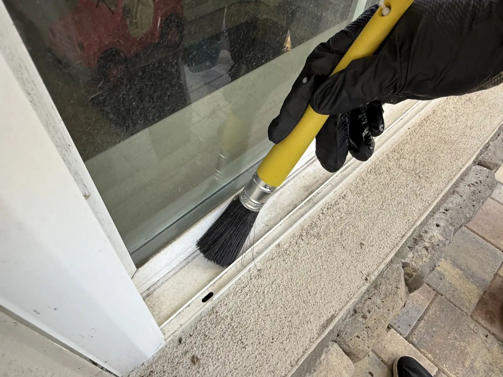 Brushing out a window sill and track in Odessa