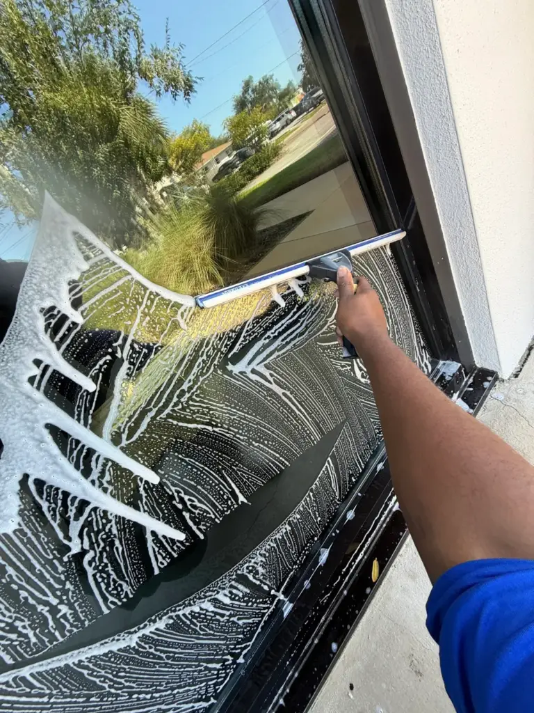 A squeegee pass pulling the soapy water off an office window