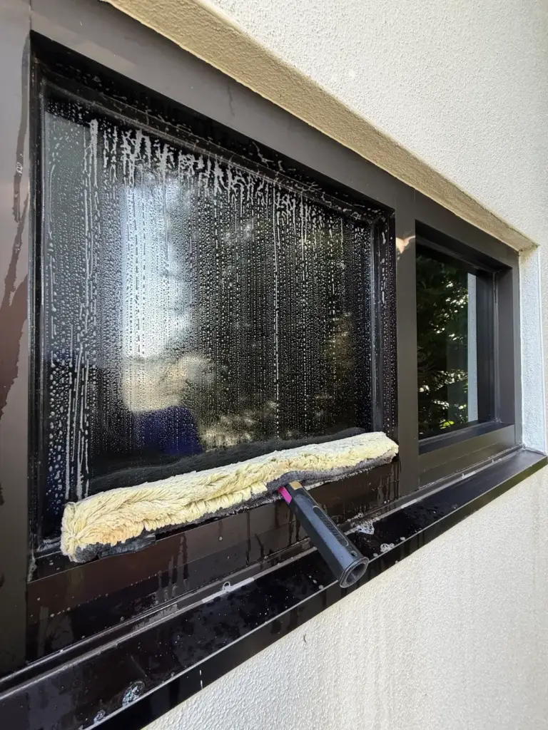 A strip washer (sponge applicator) wetting an office window