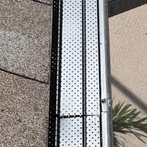Micro-perforated aluminum gutter guards installed on a shingle roof in Tampa Bay