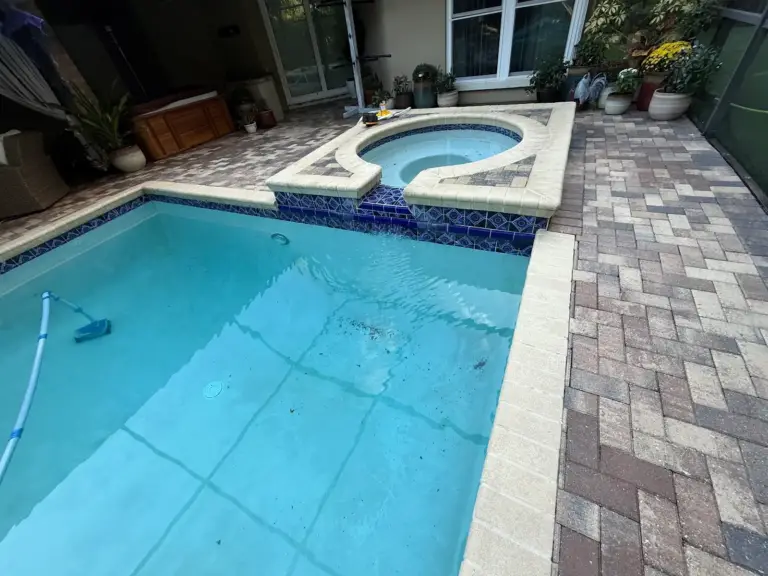 Pool and spa surrounded by clean brick pavers in Oldsmar, FL after pressure washing