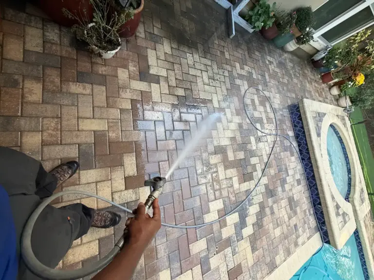 Pressure washing wand leaving a clean stripe on dirty brick pavers in Oldsmar, FL