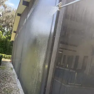 Soft washing the screens of a pool cage at low pressure