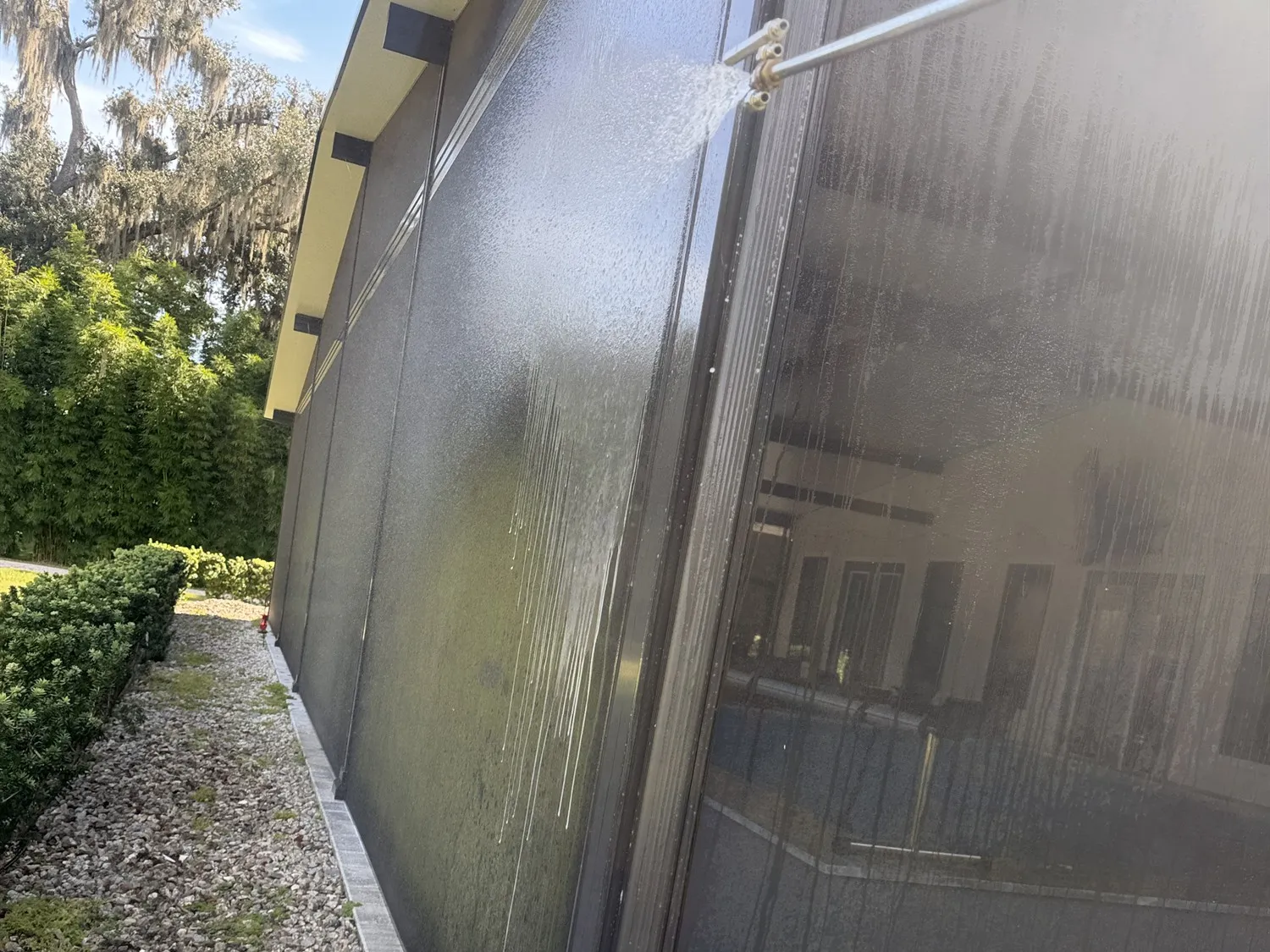Soft washing the screens of a pool cage at low pressure