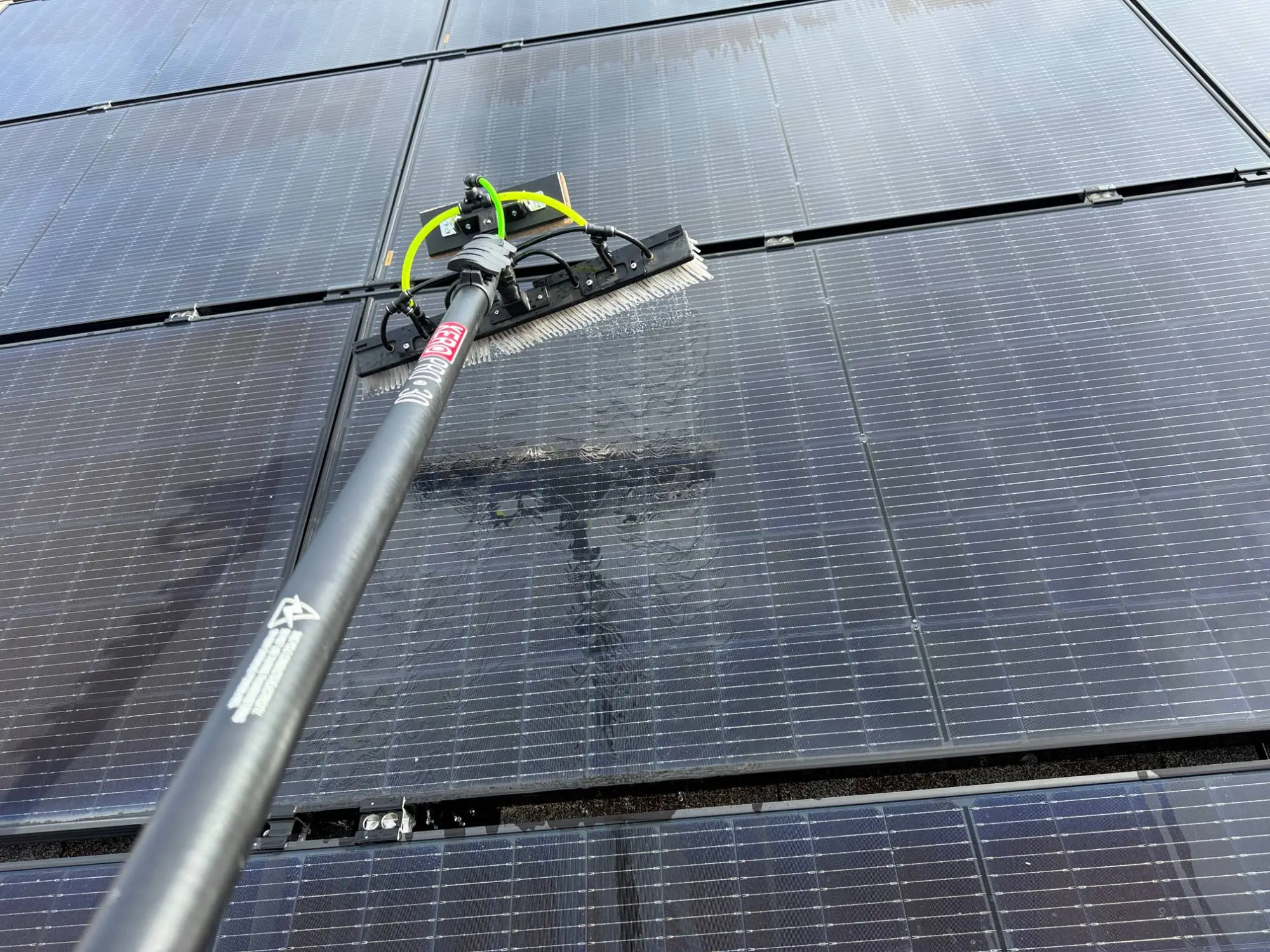 Water-fed brush pole cleaning residential solar panels in Tampa, FL