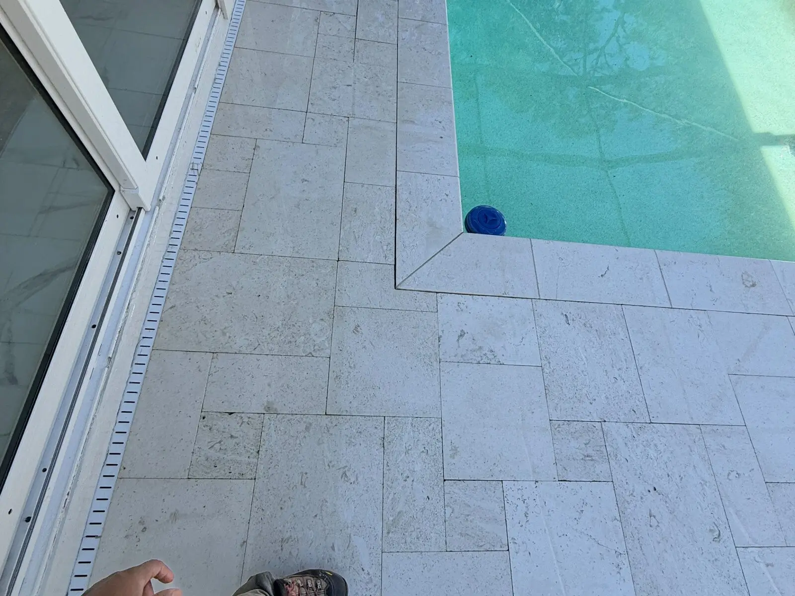 The same travertine pool deck in Lutz, FL, after pressure washing
