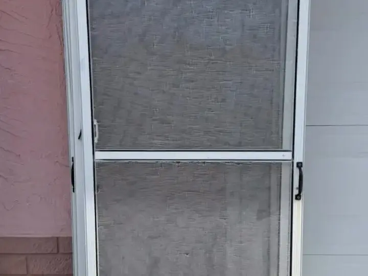 Old screen door with torn mesh in New Port Richey, before re-screening
