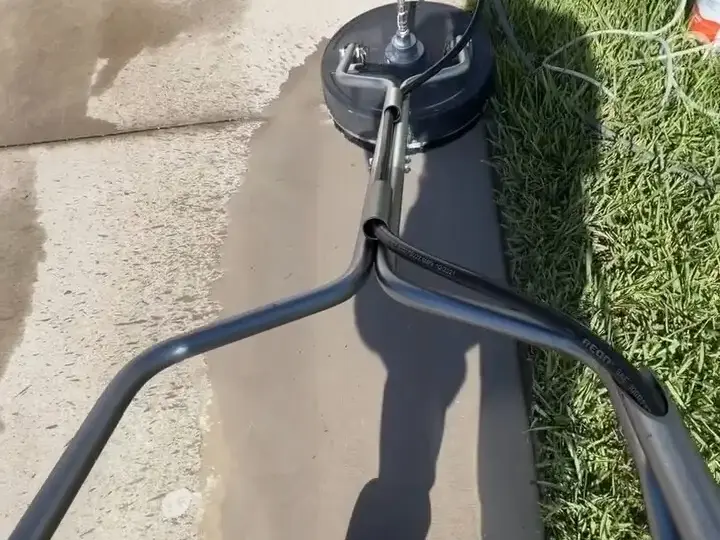 Rotary surface cleaner on a Riverview sidewalk, half cleaned