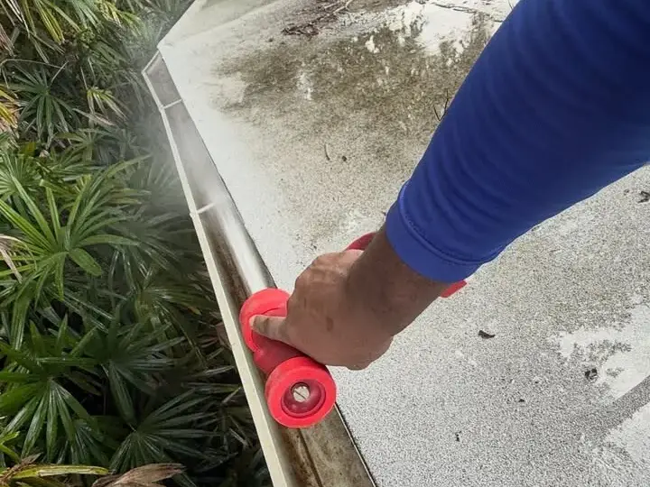 Flushing a St. Petersburg gutter with a hose nozzle after the debris came out