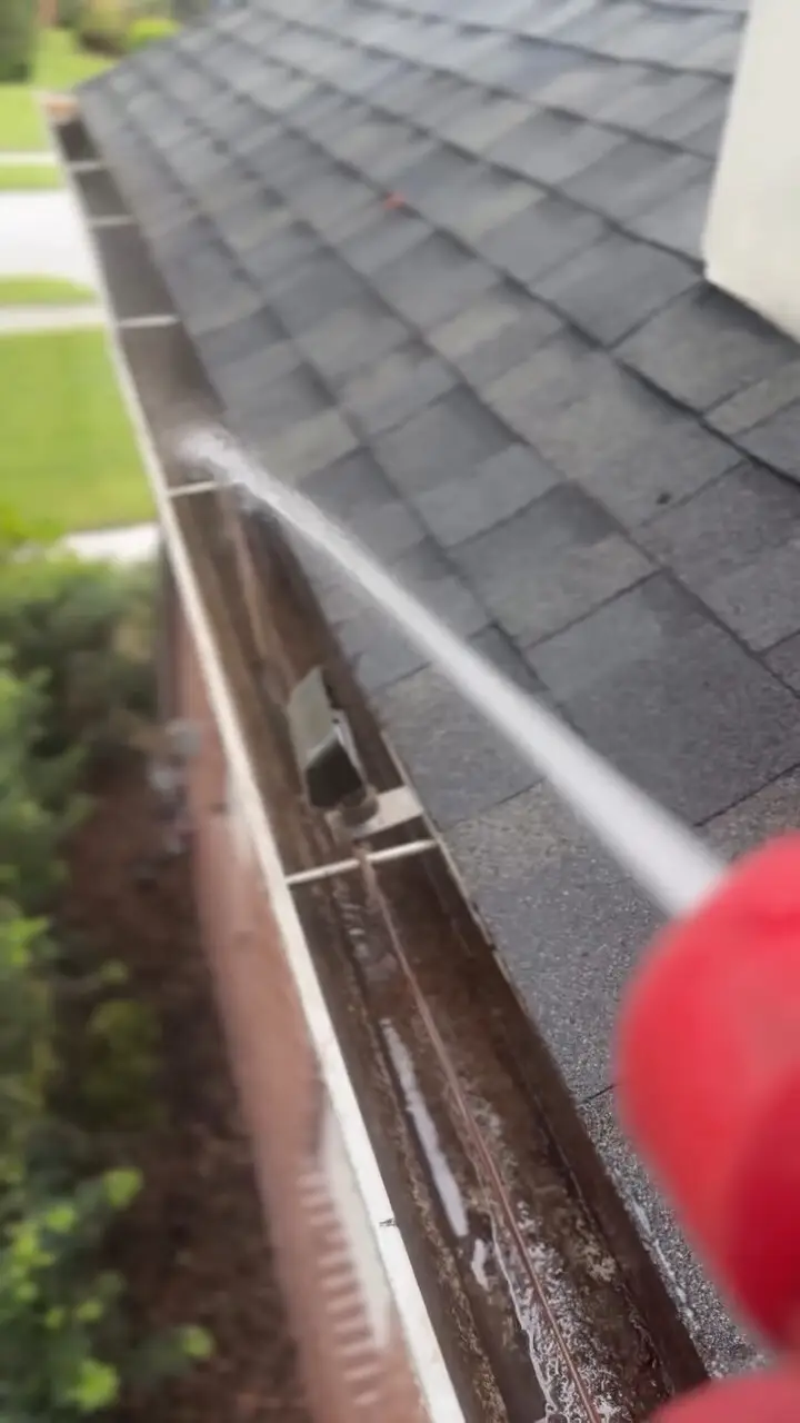 Flushing a cleared gutter with the hose in Wesley Chapel