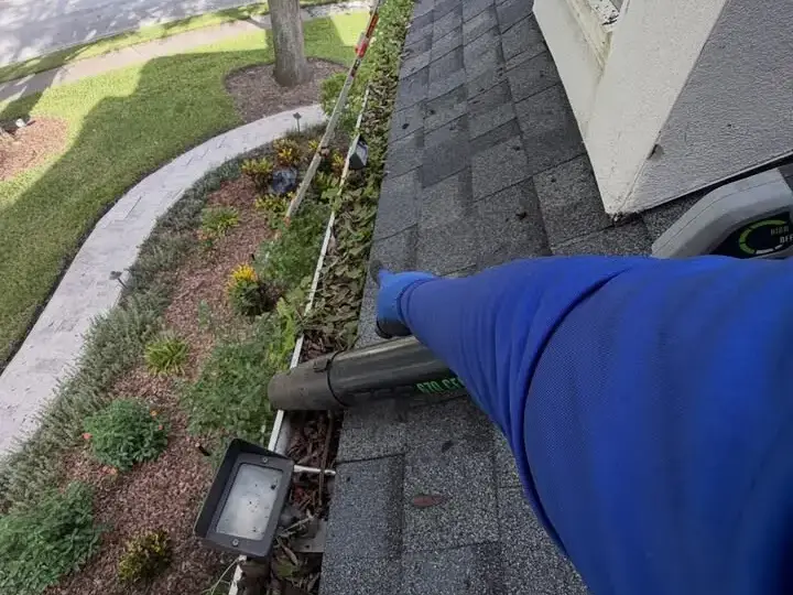 Working along the gutter of a two-story home in Wesley Chapel