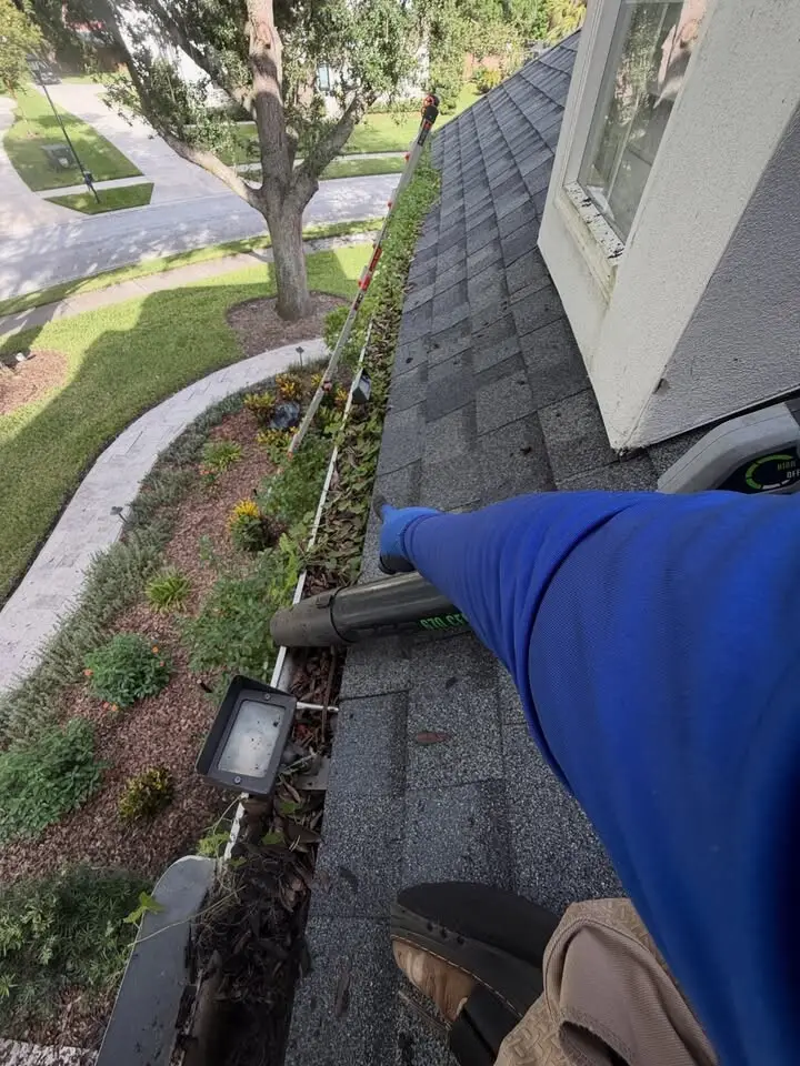 Working along the gutter of a two-story home in Wesley Chapel