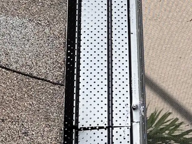 Micro-perforated aluminum gutter guards installed on a shingle roof in Tampa Bay
