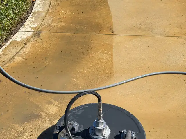 Surface cleaner leaving a clean stripe on a stained concrete driveway in Tampa, FL